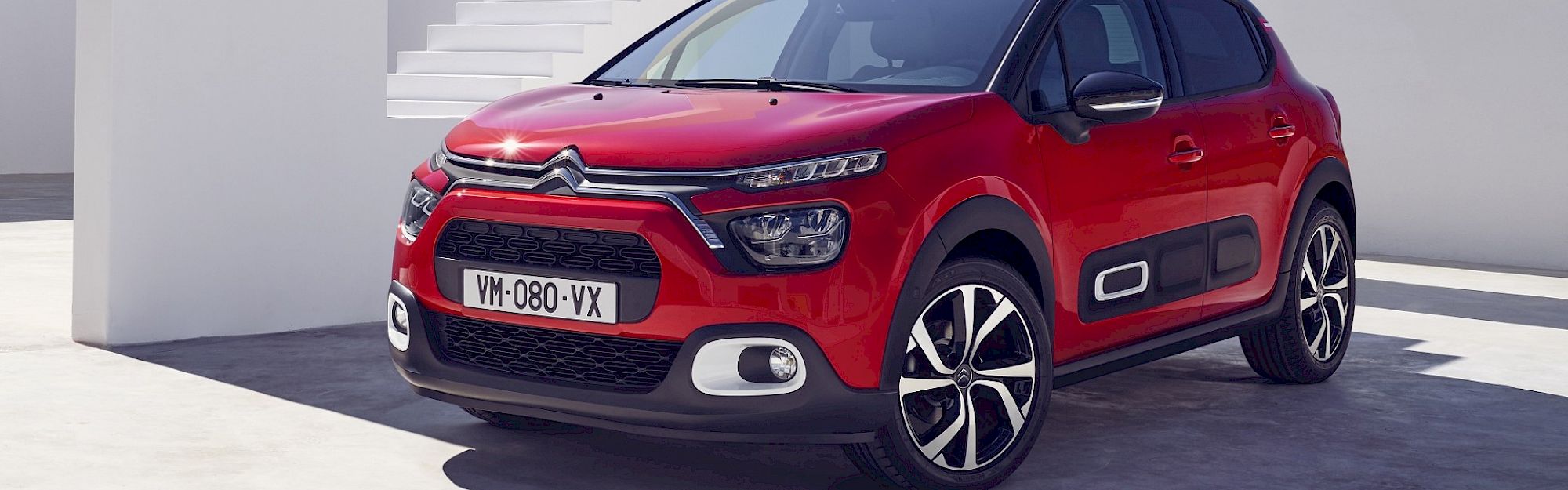 Citroën C3 áll az épület előtt